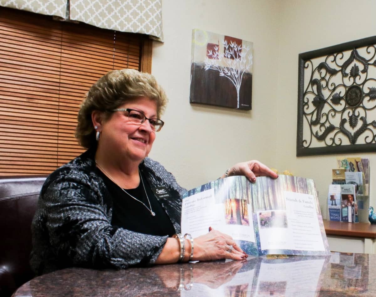 A friendly-looking woman going over a pricing catalogue