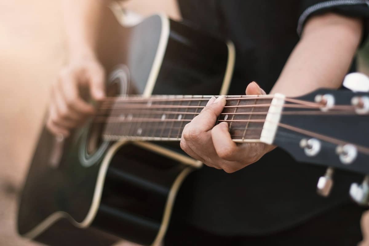 Someone playing a black guitar