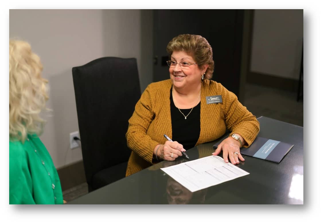 A woman helping another person with funeral planning